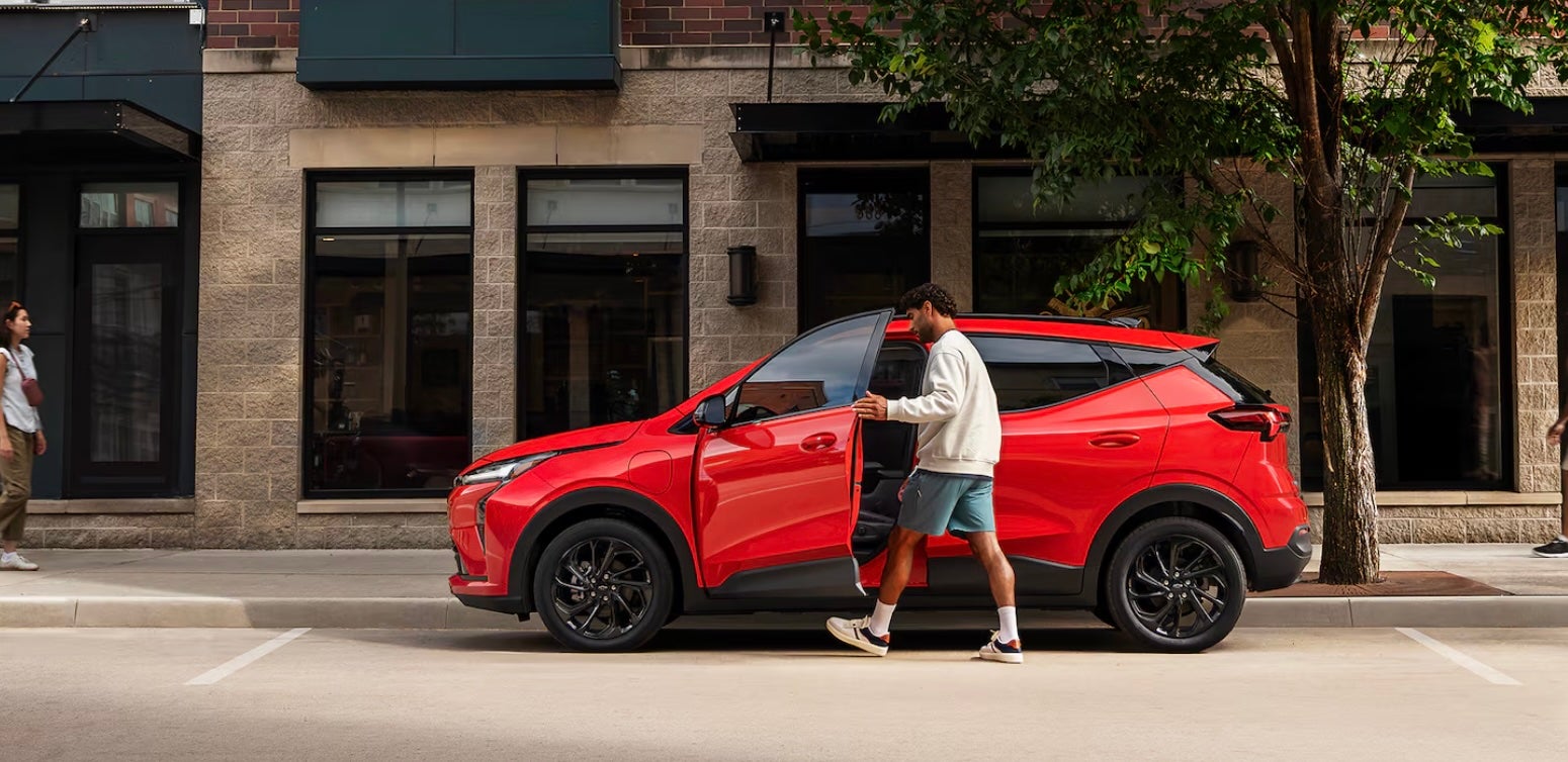 Man entering red 2027 Chevy Bolt near Dallas, TX